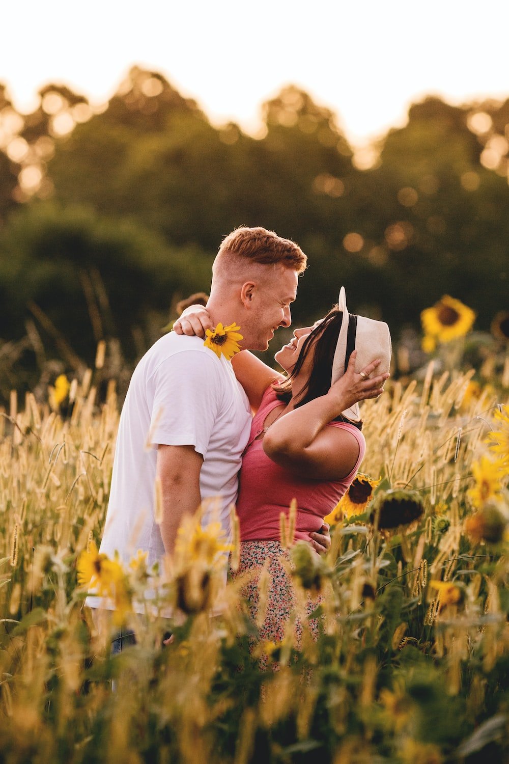 Couple embracing in a sunflower field while navigating their fertility journey together